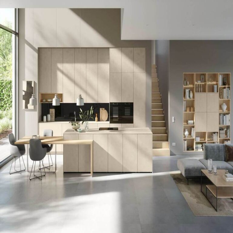 Offene moderne Küche in Beige mit Kochinsel, Essplatz und angrenzendem Wohnbereich – Küchenstudio Bremerhaven