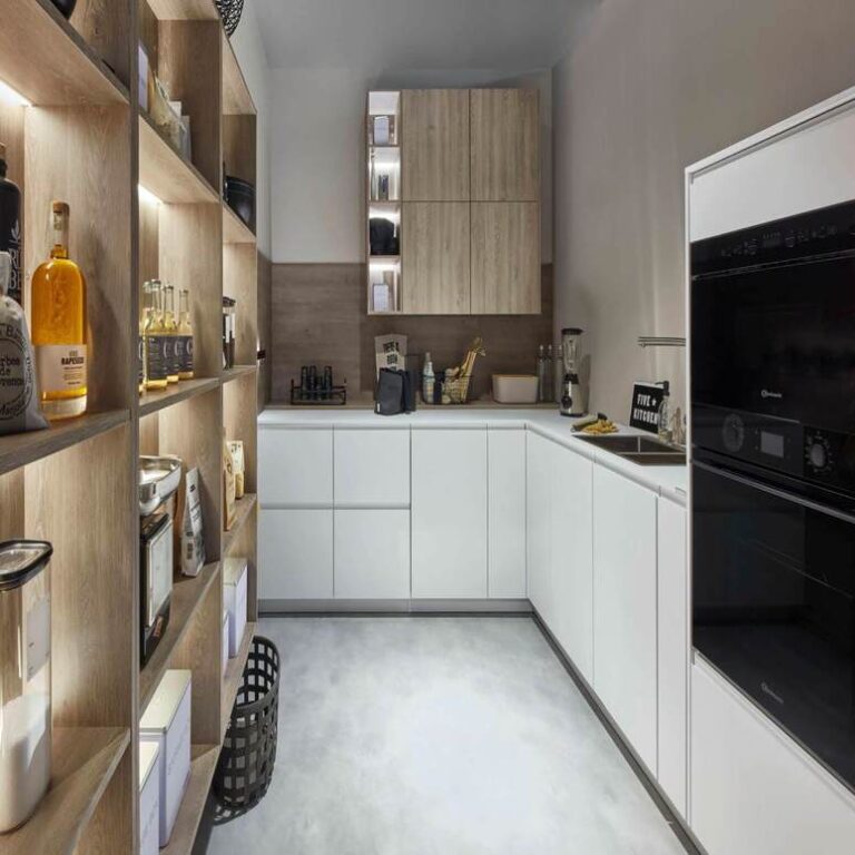 Moderne weiße Küche mit Hochschränken, Holzregal und schwarzen Einbaugeräten – Küche kaufen Bremerhaven
